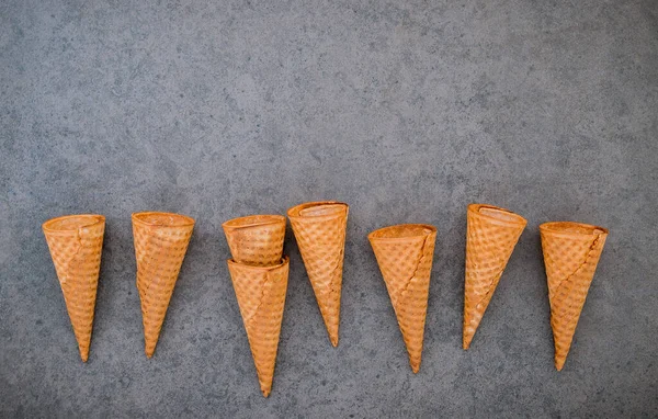 Dondurma külahları koyu taştan arka planda toplanmış. Tatlı için kopyalama alanı olan gevrek dondurma külahı..