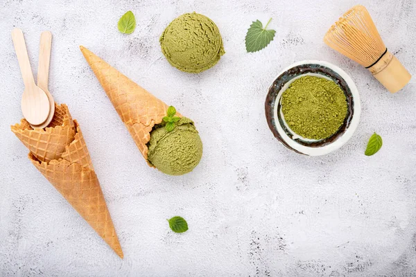 Matcha green tea ice cream with waffle cone and mint leaves  setup on white stone background . Summer and Sweet menu concept.