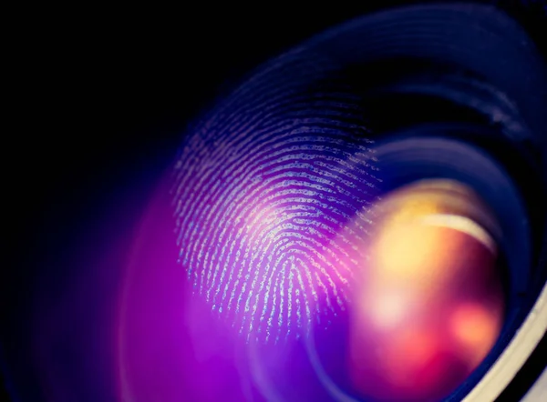 Fingerprint macro on a lens, red shadows. Biometric and security concept.