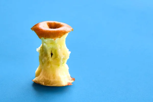 Apple core isolated on a light blue background. Eaten apple, healthy lifestyle.