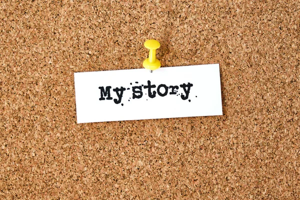 My story. Text written on a piece of paper or note, cork board background.