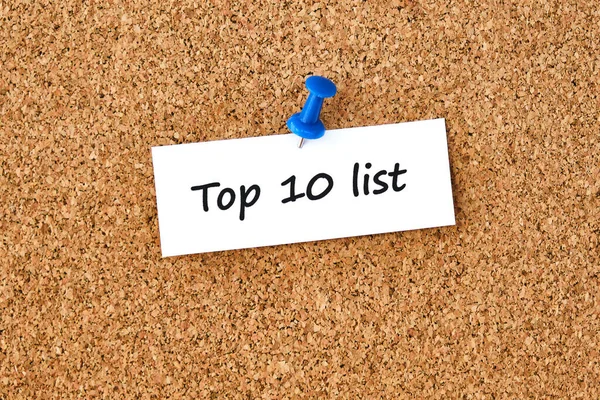 İlk 10 'da. Bir parça kağıda veya nota yazılmış metin, tıpa tahtası arkaplanı.