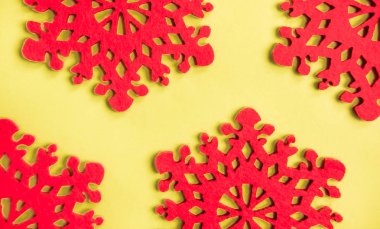 Sarı arka planda kırmızı kar taneleri.