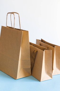 Sıfır atık alışveriş konsepti, mavi beyaz arka planda Kraft kahverengi kağıt torbaları. 