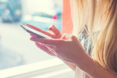  Evde akıllı bir telefon kullanan isimsiz bir kadının elini kapat, yüzü yok.