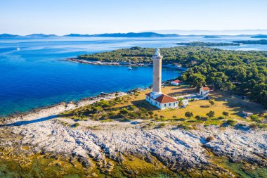 Hırvatistan, Dugi Otok adasında sabah, taş sahilde Veli Rat deniz feneri panoramik görünümü, arka planda güzel deniz manzarası