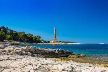 Hırvatistan, Dugi Otok adası, taş sahilde Veli Rat eski deniz feneri, ön planda güzel deniz manzarası