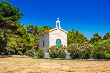 Hırvatistan, Dugi Otok Adası, çam ağaçları arasında taş sahildeki veli Rat 'ın güzel eski taş Kilisesi
