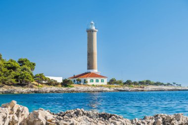 Hırvatistan, Dugi Otok adası, taş sahilde Veli Rat eski deniz feneri, ön planda güzel deniz manzarası