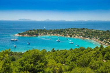 Hırvatistan'ın Murter adasındaKi Kosirina plaj lagünü, mavi denizde yelkenli tekneler ve yatlar demirledi panoramik manzara