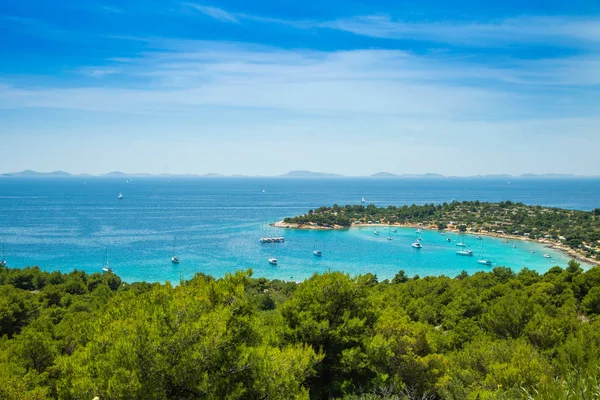 Hırvatistan, Adriyatik kıyıları, Murter adasındaki Kosirina plaj lagünü panoramik manzarası, mavi denizde yelkenli tekneler ve yatlar demirledi