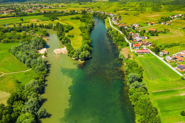 Rural countryside landscape in Croatia, confluence of Korana and Kupa rivers between agriculture fields and villages, panoramic view from drone