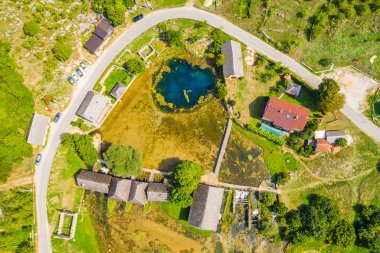 Gacka havadan insansız hava aracı görünümü Majerovo vrilo nehir kaynağı, Hırvatistan Lika bölge kırsalı, eski ahşap değirmenler ve evler