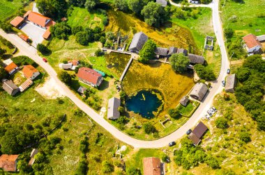 Hırvatistan, Lika bölgesi, Gacka Majerovo vrilo nehir kaynağı ve eski ahşap değirmenler ve evler havadan drone görünümü