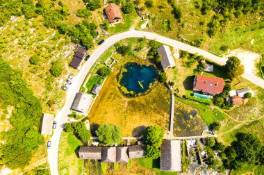 Hırvatistan, Lika bölgesi, Gacka Majerovo vrilo nehir kaynağı ve eski ahşap değirmenler ve evler havadan drone görünümü