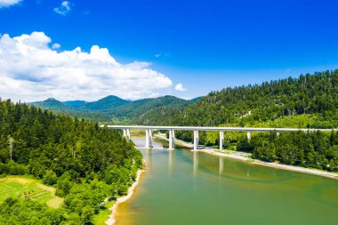 Hırvatistan, Gorski kotar, Bajer Gölü ve Fuzine karayolu köprüsü, arka planda dağlar ve orman, drone panoramik görünümü