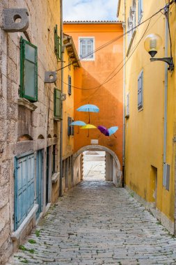 Hırvatistan, Istria, tarihi Labin kentinde güzel eski kaldırımlı caddeler, geleneksel evler ve şemsiyeler