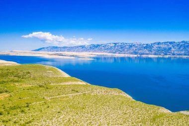 Hırvatistan ve Vrsi 'deki Adriyatik kıyı şeridi, taştan çöl ve Pag adası ve arka plandaki Velebit dağı manzarası