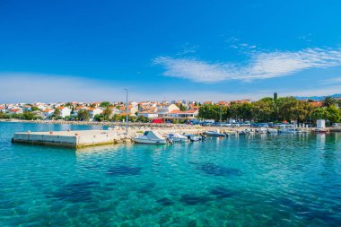 Hırvatistan, Pag adasındaki Novalja kasabası, önlerinde tekne ve turkuaz deniz, Adriyatik denizi üzerinde turizm beldesi bulunan marina