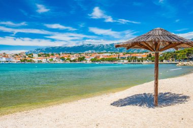 Hırvatistan 'ın Pag adasındaki Adriyatik kıyısı, Novalja kasabasındaki güzel kumsaldaki güneş şemsiyesi