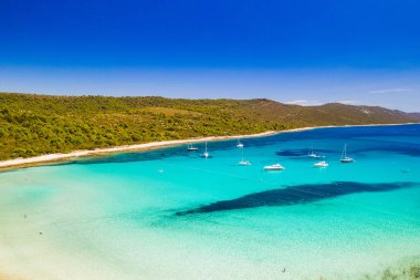 Güzel Hırvatistan. Hırvatistan 'ın Dugi Otok adasındaki Sakarun plajındaki gök mavisi turkuaz lagünün hava manzarası, açık deniz suyuna demirli yatlar.