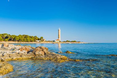 Hırvatistan 'ın Dugi Otok adasındaki Veli Rat feneri, önplanda güzel deniz manzarası ve kayalar