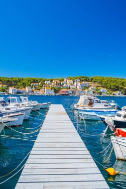 Hırvatistan 'ın Adriyatik kıyısındaki Losinj adasındaki Mali Losinj kasabası, rıhtımdaki tekneler ve arka plandaki eski evler