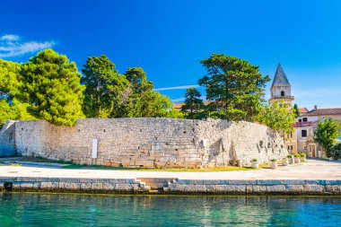 Hırvatistan 'ın Cres ve Losinj adaları arasındaki eski Osor kasabasındaki kale ve katedral kulesi, ön planda deniz manzarası