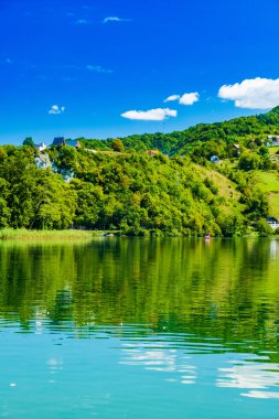 İnanılmaz yeşil Plivsko Gölü Jezero, Jajce, Bosna-Hersek, su yüzeyinde ahşap yansıması