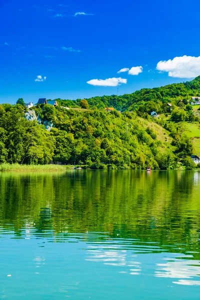 İnanılmaz yeşil Plivsko Gölü Jezero, Jajce, Bosna-Hersek, su yüzeyinde ahşap yansıması