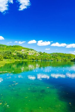 İnanılmaz yeşil Plivsko Gölü Jezero, Jajce, Bosna-Hersek, su yüzeyinde ahşap yansıması