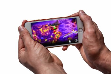 Erkek eller telefon (iPhone 7 +) tutarak ve oyun öfkeli kuşlar, beyaz arka planda izole görüntü oynuyor.