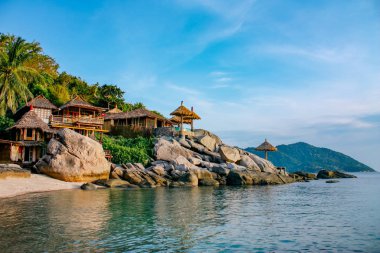 Tayland denizi, taş ve palmiye ağaçları ile Koh Tao güzel plaj tarafından eski tropikal bungalov kulübe. Cennet adası, tatil manzarası 
