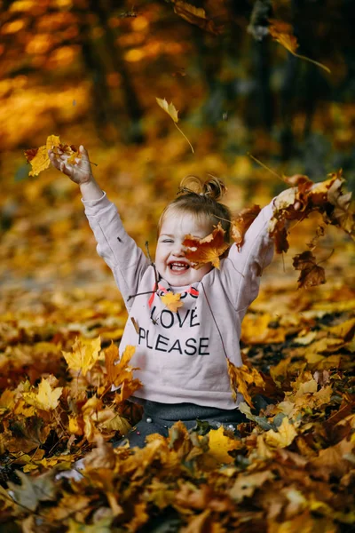 Liten Flicka Sitter Fallna Blad Park Och Roliga Kastar Gula — Stockfoto