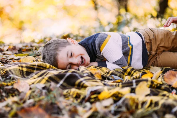 Kleiner Junge Liegt Auf Plaid Einem Herbstlichen Park Und Lacht — Stockfoto