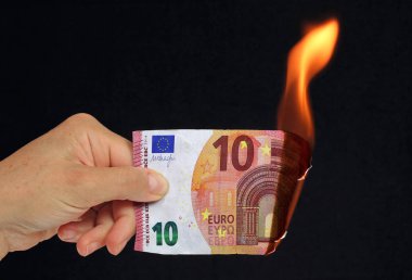 El siyah arka plan recto verso üzerinde kavramsal resim yanan 10 € banka notu tutan