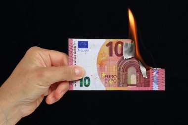 El siyah arka plan recto verso üzerinde kavramsal resim yanan 10 € banka notu tutan