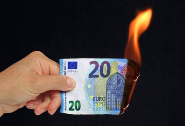 El siyah arka plan recto verso üzerinde kavramsal resim yanan 20 € banka notu tutan