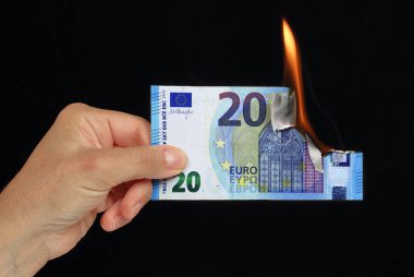 El siyah arka plan recto verso üzerinde kavramsal resim yanan 20 € banka notu tutan