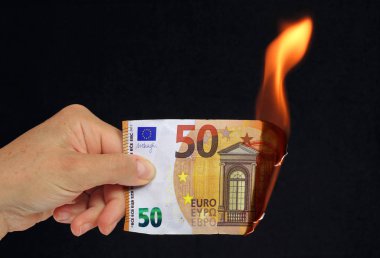 El siyah arka plan recto verso üzerinde kavramsal resim yanan 50 € banka notu tutan