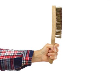 Beyaz arka planda tel fırça tutan kareli gömlekli bir işçinin el ve kolu. Ev yapımı mı yoksa ev yapımı mı olduğunu gösteren bir tasvir.