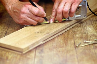 DIY, yakın plan, ahşap bir tahtaya kurşun kalemle işaret koyuyor, bir zanaatçının atölyesinde, yerde vidalar, sizin ve DIY kurslarının yaptığı konsepti gösteriyor.