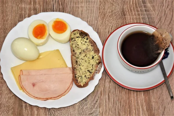 Завтрак Колбаса Сыр Яйца Хлеб Маслом Кружка Чая Деревянном Столе — стоковое фото