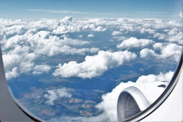 飞机机身在云彩和地球之上 — 图库照片