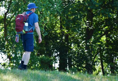 bir sırt çantası ile adam turist doğada yol boyunca gider