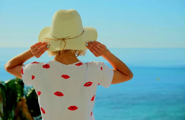 Mädchen Mit Strohhut Steht Und Blickt Auf Das Blaue Meer — Stockfoto