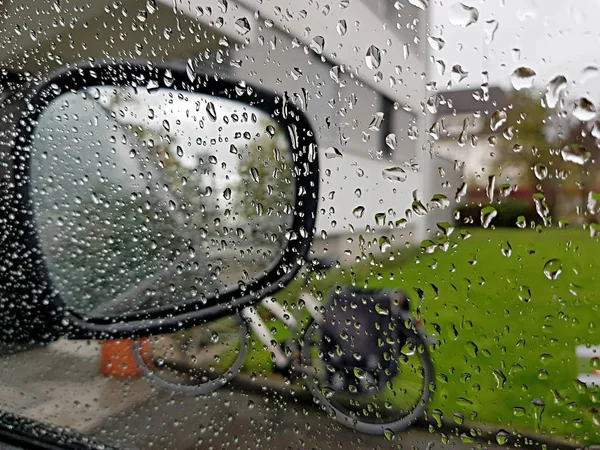 raindrops on glass, car mirror and bicycle outdoors