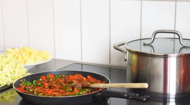 Tavada sebze, lahana, doğranmış patates ve çelik bir tava.