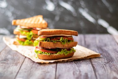 Ahşap arka plan üzerinde peynir, domates, salatalık, sosis ve salata ile Sandviç. Yatay yönlendirme