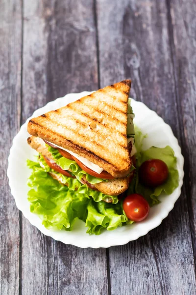 三明治与奶酪，番茄，黄瓜，香肠和生菜在木制背景。垂直方向 — 图库照片